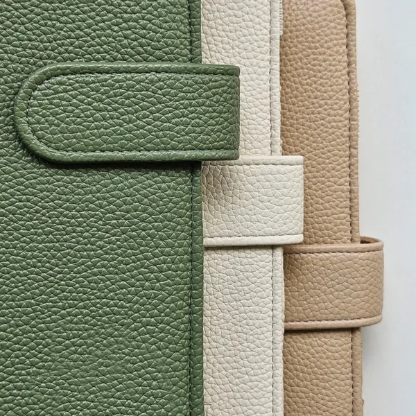 odiniu-planuokliu-virseliu-spalvu-palete Trijų odinių planuoklių viršelių spalvų paletė: alyvuogių žalia, šviesiai kreminė ir šilta smėlio spalva.