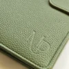 zalias-odinis-planuoklis-uzdaras Žalio odinio planuoklio viršelio tekstūros detalė su įspausduotu MP logotipu.